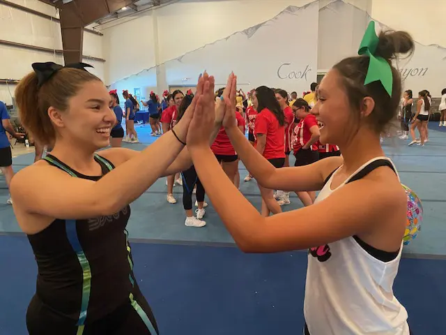 Two girls are giving each other a high five.